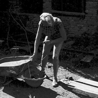 Construction workers mixing concrete manually.