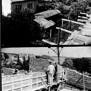 Construction workers installing wooden roofing on a building.
