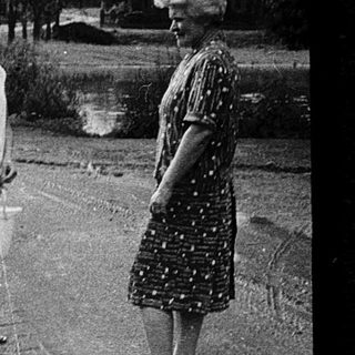 Two adults and two children walking outdoors in residential area.