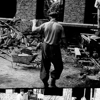 Historical construction site with workers assembling machinery.