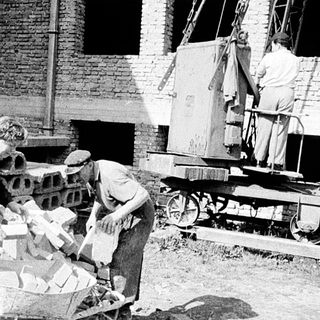 Historic bricklaying and construction workers at site.