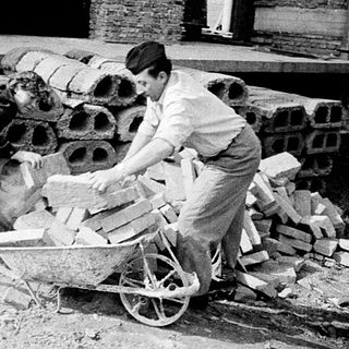 Construction workers handling bricks and materials on-site.