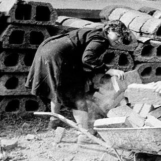 Construction workers handling bricks and materials on-site.