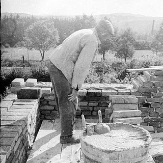Traditional stone masonry and mortar preparation.