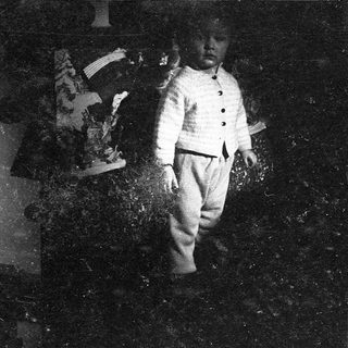 Vintage photo of boy playing with old TV.