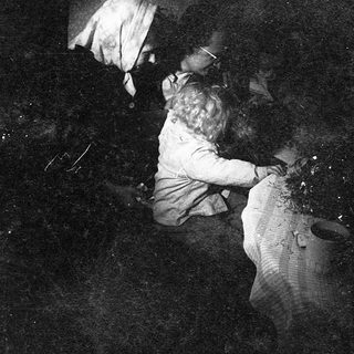 "Two individuals lying on floor amid scattered debris."
