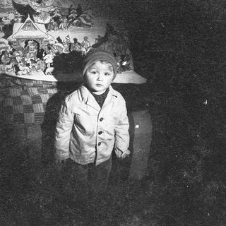 Young child in winter coat, looking solemn.