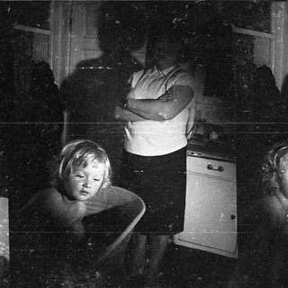 Intimate indoor scene: woman and child in dimly lit room.