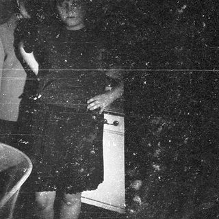 Blurry nighttime photo of person holding white object.