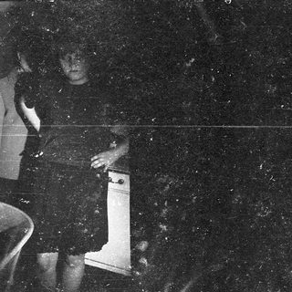 Blurry nighttime photo of person holding white object.