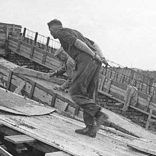 Construction workers assembling wooden framework.