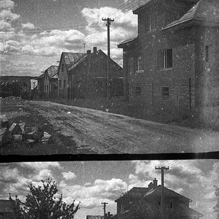 Vintage black-and-white street with old buildings and flood damage.