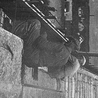 Vintage street scene with person leaning on wall.