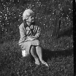 A person sitting alone outdoors near water.
