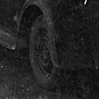 Vintage car on winding road near construction sign.