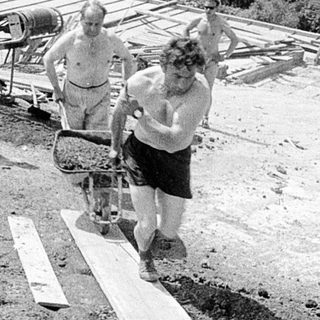 Construction site with workers assembling wooden structures.