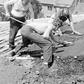 Two men repairing wooden roof decking.