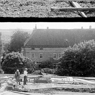 Construction site with wooden framework and workers.