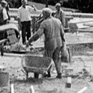 Construction site with wooden framework and workers.