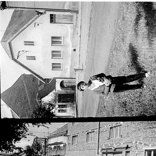 Two boys skateboarding in urban residential area.