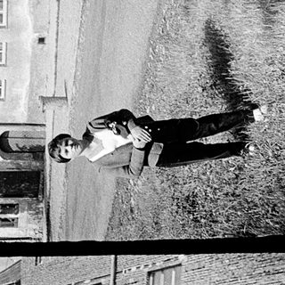 Two boys skateboarding in urban residential area.