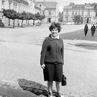 Construction site and completed building with woman standing nearby.