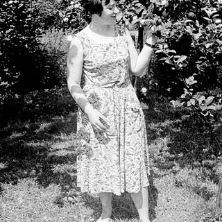 Two women posing outdoors in vintage dresses, mid-20th century.