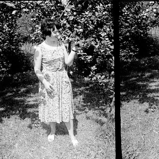 Two women posing outdoors in vintage dresses, mid-20th century.