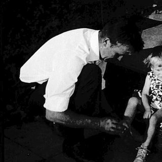 Children and adult at nighttime gravestones.