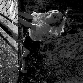 Two children playing on a swing set at dusk.