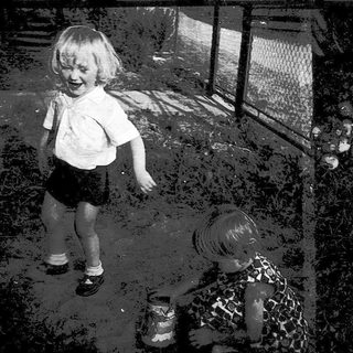 Young child playing near animal enclosure.
