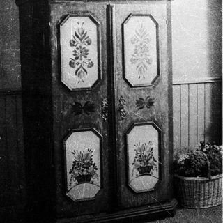 Vintage floral-patterned wooden wardrobe with decorative panels.