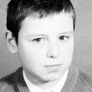 Black-and-white portrait of a young boy in a sweater.