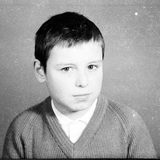 Black-and-white portrait of a young boy in a sweater.
