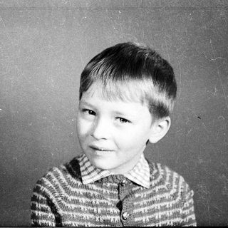 Young boy in striped sweater, mid-20th century portrait.