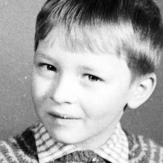 Young boy in striped sweater, mid-20th century portrait.