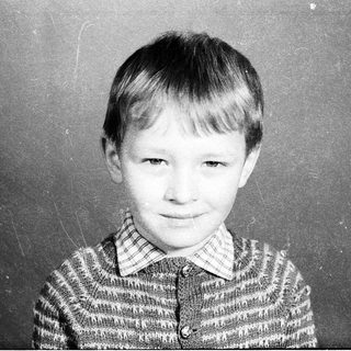 Young boy in striped sweater, mid-20th century portrait.