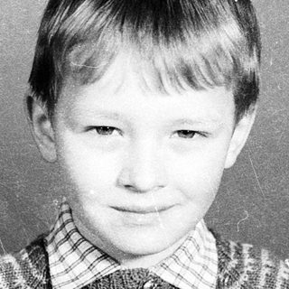 Young boy in striped sweater, mid-20th century portrait.