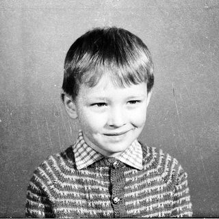 Young boy smiling in vintage school portrait.