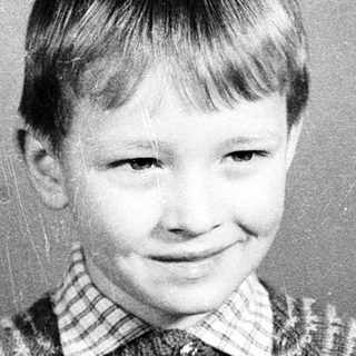 Young boy smiling in vintage school portrait.
