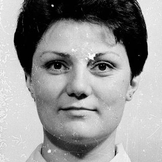 Black-and-white portrait of a woman in plaid shirt.