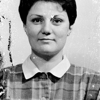 Black-and-white portrait of a woman in plaid shirt.