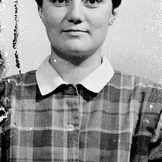 Black-and-white portrait of a woman in plaid shirt.