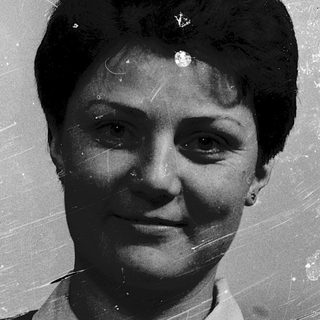 Vintage black-and-white portrait of a woman smiling.