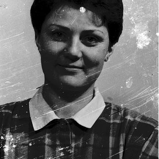 Vintage black-and-white portrait of a woman smiling.