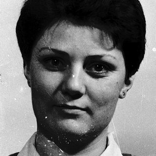Black-and-white portrait of a woman in plaid shirt.