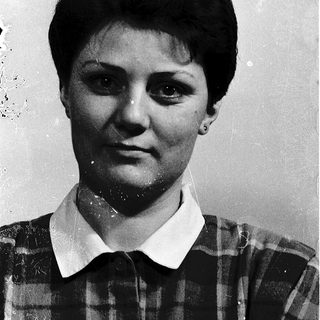 Black-and-white portrait of a woman in plaid shirt.
