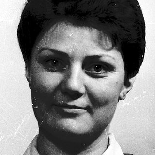 Black-and-white portrait of a woman in plaid shirt.