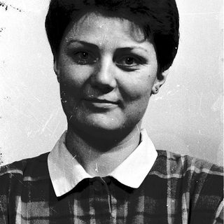 Black-and-white portrait of a woman in plaid shirt.