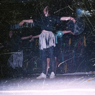 Two dancers performing in dark, rain-soaked environment.